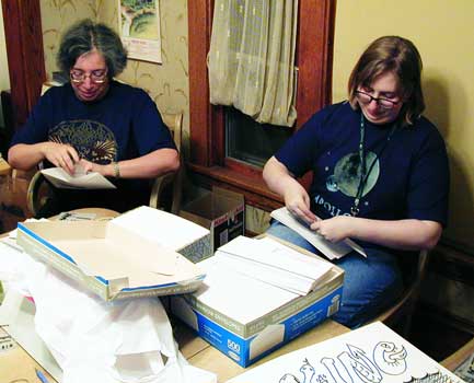 Beth and Laurel prepare registration packets 